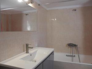 a bathroom with a sink and a mirror and a tub at Comfortable Thermi apartment near SKG Airport in Thérmi +4 photos