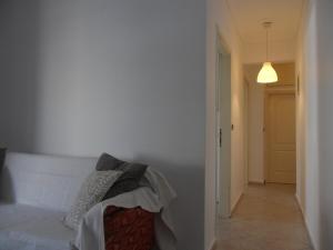 a bedroom with a white bed and a hallway at Comfortable Thermi apartment near SKG Airport in Thérmi