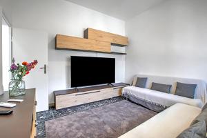 Una sala de estar con un sofá y un televisor de pantalla plana. en La Siesta - Happy Rentals, en Torre del Lago Puccini