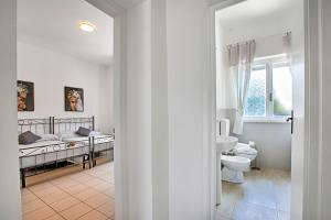 1 dormitorio con 2 camas y baño con aseo en La Siesta - Happy Rentals, en Torre del Lago Puccini