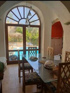 a kitchen with a table and chairs and a window at Sou Villa in El Alamein