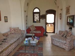 a living room with two couches and a tv at Sou Villa in El Alamein