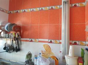 a kitchen with orange tiles on the wall and a sink at Sou Villa in El Alamein