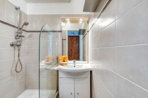 une salle de bain avec un lavabo, une douche et un miroir dans l'établissement Appartement à 70m de la plage, à La Grande Motte 17 autres photos