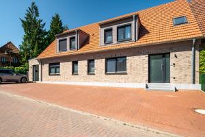 a house with a brick driveway in front of it at Ferienwohnung ScheunenBlick in Göhren-Lebbin