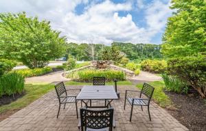 北斯托宁顿Bellissimo Hotel, Trademark by Wyndham Near Foxwoods Casino的花园里有一个带桌椅的露台