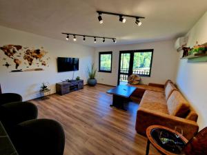 a living room with a couch and a tv at Rebeka Luxury Apartment in Tryavna