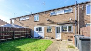 a brick house with a fence and a yard at City Vacations Corby 4 separate room house in Corby