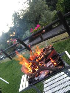a fire in a grill next to a bench at Villino Isò in La Spezia +12 photos