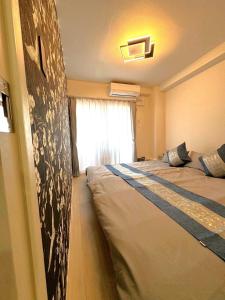 ein Schlafzimmer mit einem großen Bett in einem Zimmer in der Unterkunft K square 400 in Nagoya
