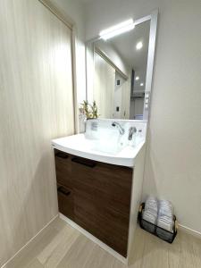 ein Badezimmer mit Waschbecken und Spiegel in der Unterkunft K square 400 in Nagoya + 14 Fotos