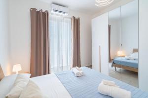 a bedroom with a large bed and a mirror at Casa Alejandra a Pachino centro in Pachino