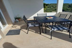 a black table and chairs on a patio with a view at Two Bedroom Apartment with Sea View in Slano