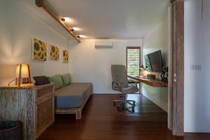 a bedroom with a bed and a desk with a computer at Flow Gili Air in Gili Islands