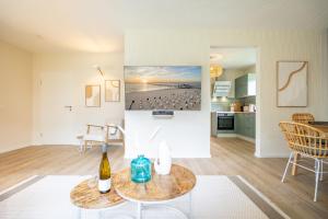 a living room with a table and a kitchen at Ferienhaus Strandnest in Ahlbeck