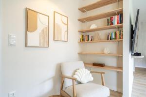a living room with a chair and bookshelves at Ferienhaus Strandnest in Ahlbeck
