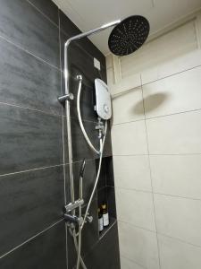 a shower with a shower head in a bathroom at Tranquil Transit Horizon Suites in Kampong Melot