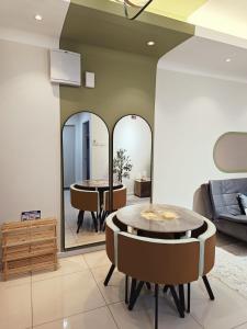 a living room with a table and two mirrors at Tranquil Transit Horizon Suites in Kampong Melot