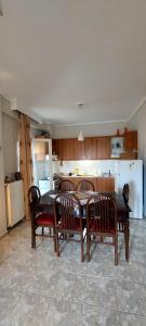 a dining room with a table and chairs and a kitchen at Watermelon Home in Nea Moudania +16 photos