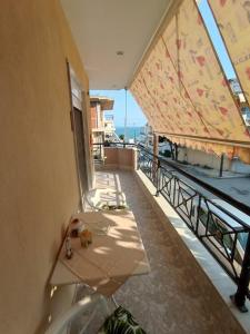 a balcony with a table and a view of the ocean at Watermelon Home in Nea Moudania