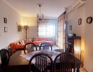 a living room with a table and chairs and a couch at Watermelon Home in Nea Moudania