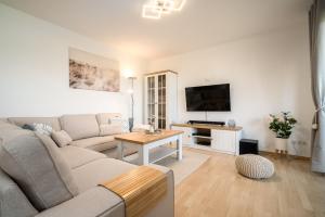 a living room with a couch and a tv at One Putt Erdgeschoss in Göhren-Lebbin
