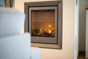 a fire in a brick fireplace in a room at One Putt Erdgeschoss in Göhren-Lebbin +9 photos