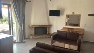 a living room with a couch and a fireplace at Vontzos Hotel in Achladies