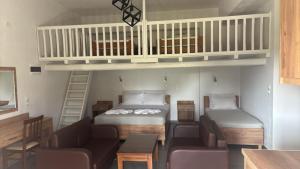 a small room with two beds and a loft at Vontzos Hotel in Achladies