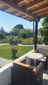 a patio with a table and chairs and a yard at Vontzos Hotel in Achladies