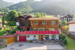 een groot huis met een rood dak in een dorp bij Haus Barbara in Sankt Gallenkirch
