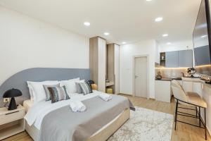 赫尔采格诺维Swisslion Studios的一间带一张白色大床的卧室和一间厨房