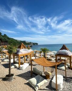 a group of tables and umbrellas on a beach at Vila Reževići in Budva