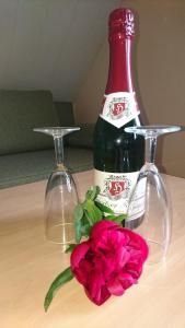 eine Flasche Wein und eine Blume auf dem Tisch in der Unterkunft Heidebistro in Commerau