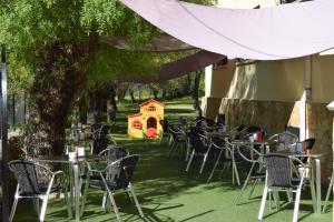 un grupo de mesas y sillas bajo un árbol en Hotel Rural Marcos en Rascafría