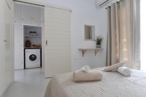 a white bedroom with a bed and a washing machine at Vagia Calm House in Parikia