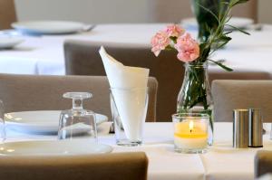 ein Tisch mit einer Blumenvase und einer Kerze in der Unterkunft Teos Lodge Pansiyon in Siğacık