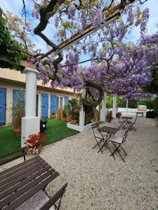 a picnic table and a tree with purple flowers at Chez Louis in Les Issambres