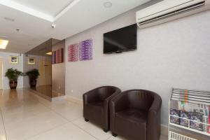 a waiting room with two chairs and a television on a wall at ZEN Rooms Metro Hotel @ KL Sentral in Kuala Lumpur +30 photos