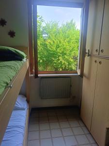 a small room with a window with a bed and a radiator at Grazioso bilocale in Giusvalla