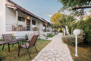 a patio with chairs and a table in front of a building at Skafonas Apartments in Pelekas