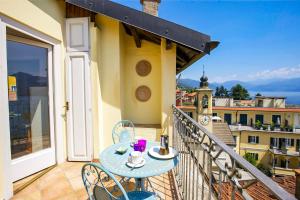 a table and chairs on a balcony with a view at Appartamento Ronco in Ghiffa