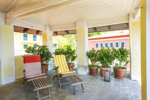 two chairs sitting on a porch with potted plants at Appartamento Ronco in Ghiffa