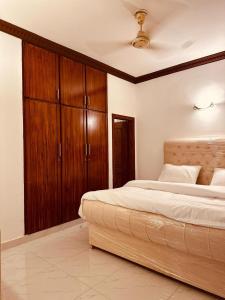 - une chambre avec un grand lit et des placards en bois dans l'établissement F-10 park tower, à Islamabad 8 autres photos