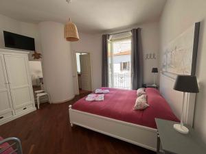 a bedroom with a bed with red sheets and a window at Affittacamere Villa Silvia in Follonica +23 photos