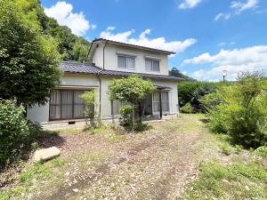 una casa blanca en medio de un patio en 赤磐ベース, en Akaiwa