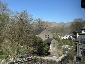 a group of houses in a town with a stone fence at Rothay Cottage in Ambleside