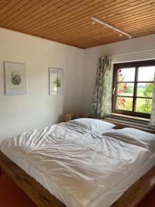 a large bed in a bedroom with a window at Waldhaus Wiesenblick mit Spielzimmer und Tischtennisraum in Borchen