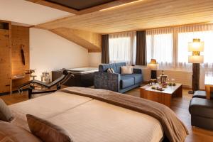 沙尔梅Hôtel Cailler & Bains de la Gruyère的一间带床和客厅的酒店房间