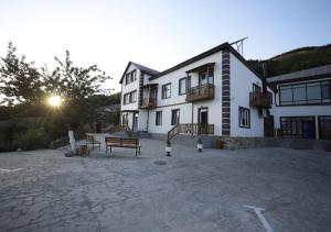 un grande edificio bianco con una panchina di fronte di ANGINE Resort Hotel a Vanadzor